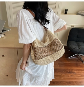 Close-up of beige straw woven bag with hollow mesh design and brown leather strap