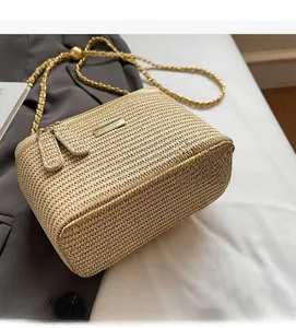 Detail einer Mini-Strohtasche mit goldener Kette und kugelförmiger Metallschnalle