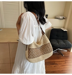 Detail of a woven straw tote bag with brown leather straps and mesh pattern details