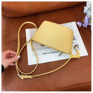 Detailed macro view of yellow lychee leather shell bag with silver heart charm and logo