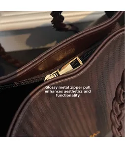 Close-up of golden hardware zipper and woven texture on a brown tote bag
