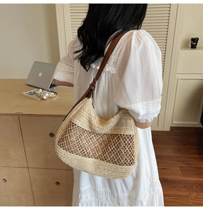 Detail view of woven straw tote bag with brown leather strap and mesh knitting pattern