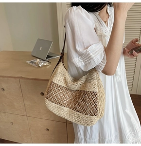 Close-up of a woven straw shoulder bag featuring mesh cutouts and a bohemian summer style