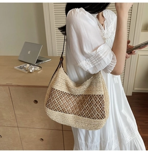 Detailed shot of straw shoulder bag featuring wavy weave pattern and brown leather strap