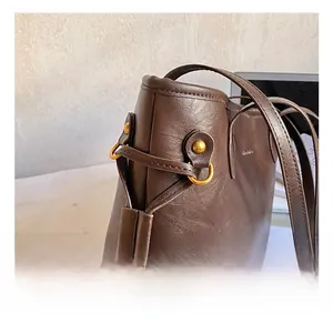 Detailed shot of brown tote bag with gold metal rings and smooth leather texture