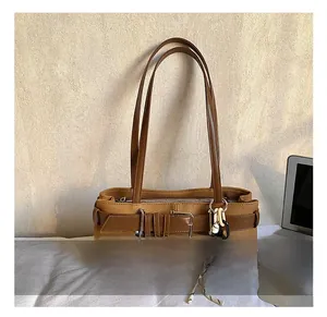 Détail du sac hobo vintage marron avec brides à boucle et pendentif en corde tissée