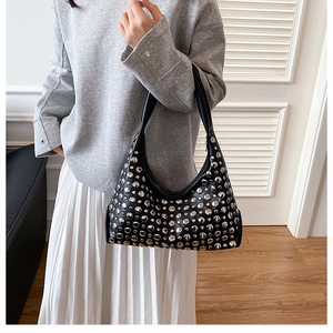 Detailaufnahme der schwarzen Hobo-Tasche mit Silbernieten und glatter Halbmondform
