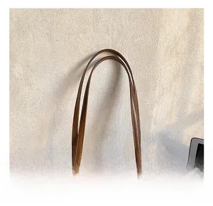 Détail du sac à main vintage en toile marron et cuir avec anses robustes et fermeture éclair