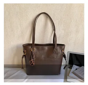 Detail view of large dark brown leather tote bag with side drawstring and long straps