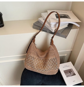 Close-up of woven straw shoulder bag with white mesh layer and brown leather strap