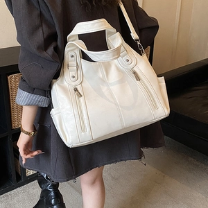 Gros plan du sac cabas en cuir PU blanc ivoire montrant la poche latérale et les zips