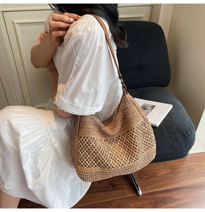 Detail of a brown hand-woven straw shoulder bag with unique hollow mesh pattern