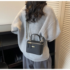 Modell mit schwarzer quadratischer Handtasche mit Kette und strukturiertem Lederdesign