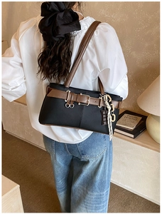 Détail du sac vintage noir avec touches de cuir marron et pendentif en corde tressée