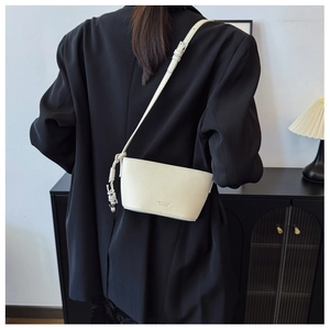 Detail view of cream crossbody bag in pebbled leather with silver bead and knot