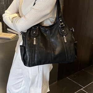 Détails du sac cabas en similicuir noir avec fermetures éclair et rivets argentés