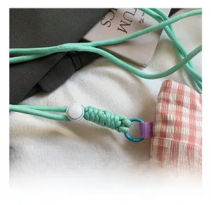 Détail du sac en tissu à carreaux avec sangle tressée vert menthe et crochet en métal bleu