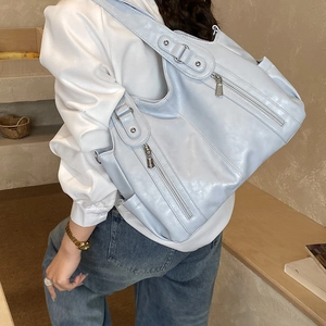 Détail du sac cabas bleu clair montrant le cuir perlé et les fermetures éclair latérales