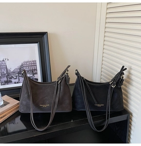 Détail de sacs à bandoulière en cuir avec lettrage doré et coutures blanches