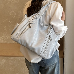 Détail du cabas bleu clair montrant la texture raffinée et les poches zippées verticales