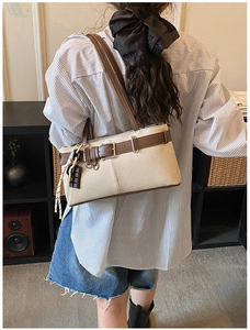 Détail d'un sac porté épaule vintage en toile et cuir avec pendentif chocolaté