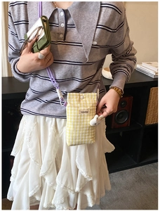 Détail du petit sac à bandoulière à carreaux jaune avec breloque lapin et cordon violet