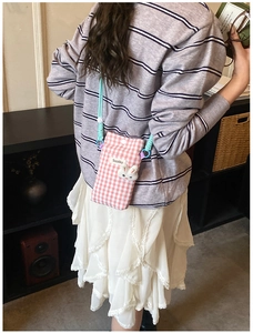 Détail du sac à bandoulière rose à carreaux avec charm lapin mignon et sangle tissée pour téléphone