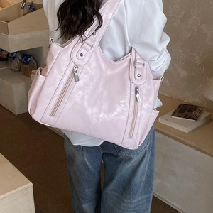 Détail d'un grand sac cabas rose en cuir synthétique avec poches à double fermeture éclair
