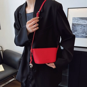 Chic red lychee leather crossbody bag with heart pendant and adjustable strap for women