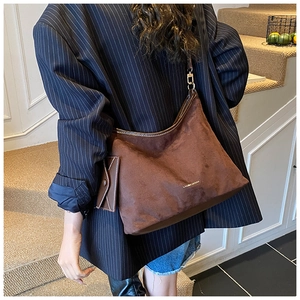 Detail view of dark brown suede tote bag featuring a detachable matching coin purse charm