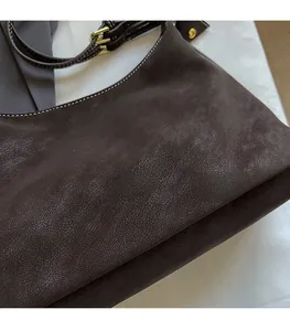 Gros plan sur la texture du cuir marron foncé avec logo Fashion & Bags et coutures blanches