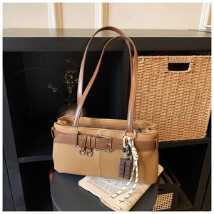 Détail du sac à bandoulière en toile marron avec ceinture en cuir et boucle décorative