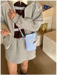 Détail du sac à bandoulière pour téléphone à carreaux bleu et blanc avec sangle tressée