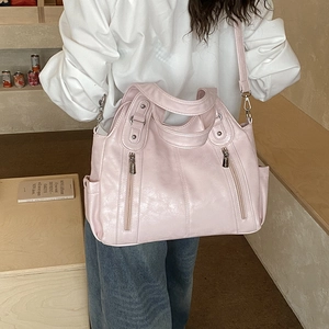 Détail d'un grand sac cabas rose montrant les poches latérales et boucles argentées