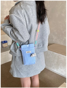 Détail du sac de téléphone vichy bleu avec sangle tressée colorée et breloque lapin