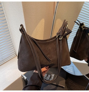 Détail du sac en cuir suédé marron café avec surpiqûres blanches et logo de marque