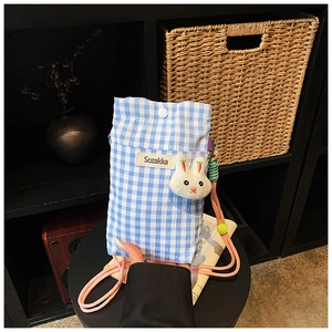 Vue détaillée du sac pour téléphone à carreaux avec breloque lapin et bandoulière