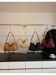 Dettaglio di quattro borse tote in camoscio nei colori caramello, beige, nero e bordeaux