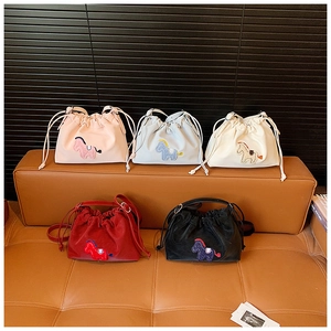 Detail view of five colorful drawstring bucket bags with cartoon horse embroidery