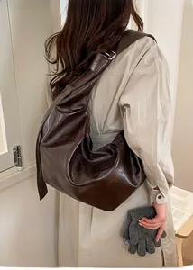 Détail d'un sac hobo en cuir PU marron foncé avec bandoulière réglable sur un mannequin