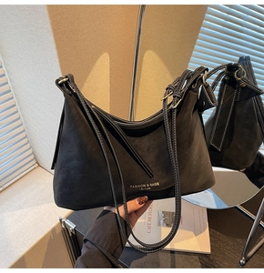 Détail du sac bandoulière en cuir mat noir avec surpiqûres blanches et garnitures dorées