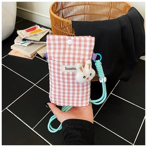 Détail du sac de téléphone à carreaux roses avec bouton pression et breloque lapin
