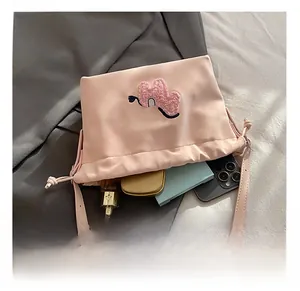 Pink drawstring bucket bag detail showing internal storage for phone and perfume