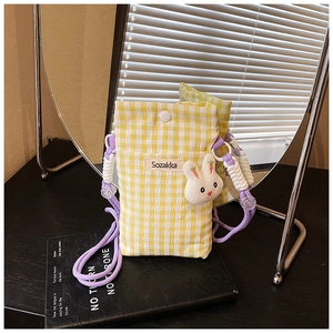 Détail du sac de téléphone à carreaux jaunes avec pendentif lapin et sangle mauve
