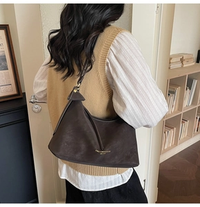 Sac à bandoulière en cuir marron foncé dans un décor de style de vie intérieur