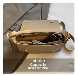 Internal view of khaki crossbody bag showing spacious main compartment and zip pocket