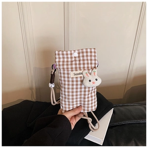 Détail du sac de téléphone à carreaux avec breloque lapin et étiquette de marque