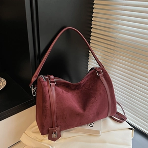 Dettaglio della borsa tote in pelle scamosciata bordeaux con lucchetto in metallo argentato