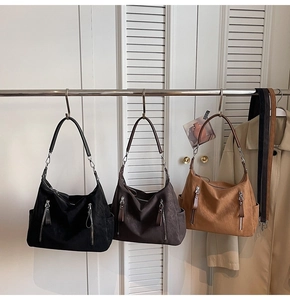 Trois grands sacs hobo minimalistes en noir, marron et camel avec poches zippées