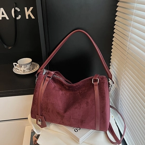 Dettaglio della borsa tote in pelle scamosciata bordeaux con lucchetto metallico elegante